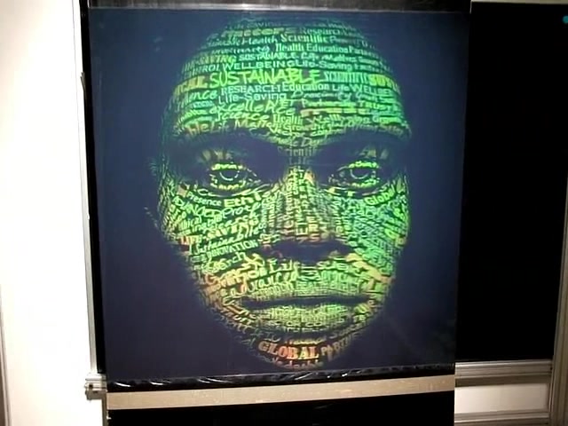 The lenticular print mounted in a workshop, the typographic portrait visible on the panel.